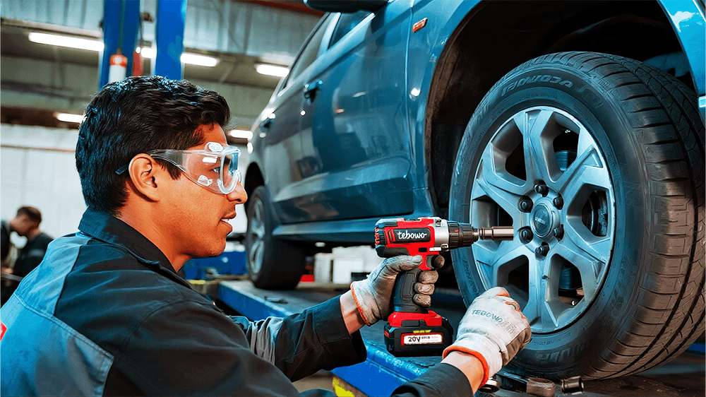 Mechanic removing a car wheel with a cordless impact wrench
