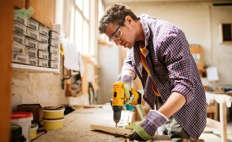 Cordless drill used in a workshop with 110V tools