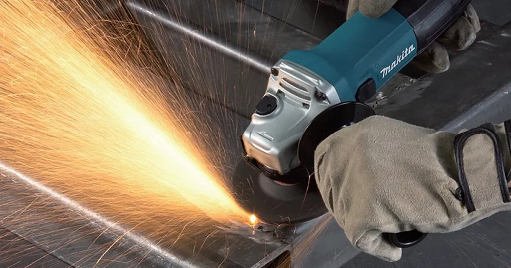 Angle grinder cutting a metal pipe with sparks