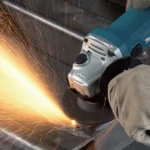 Angle grinder cutting a metal pipe with sparks