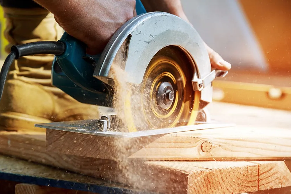 Circular saw cutting a thick timber board