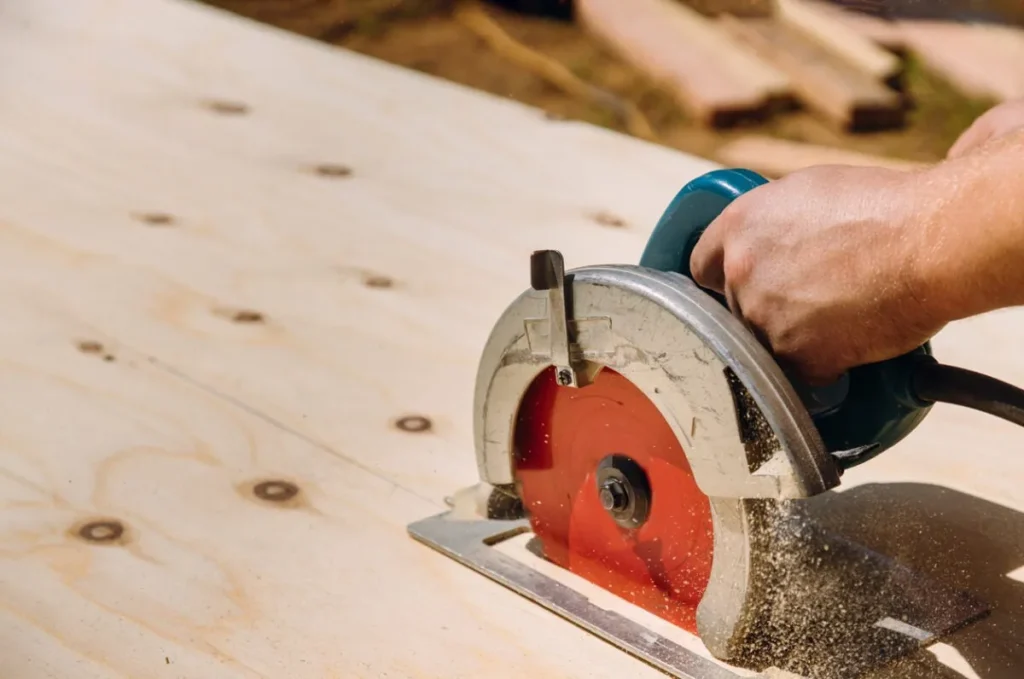Handheld circular saw cutting a wooden board