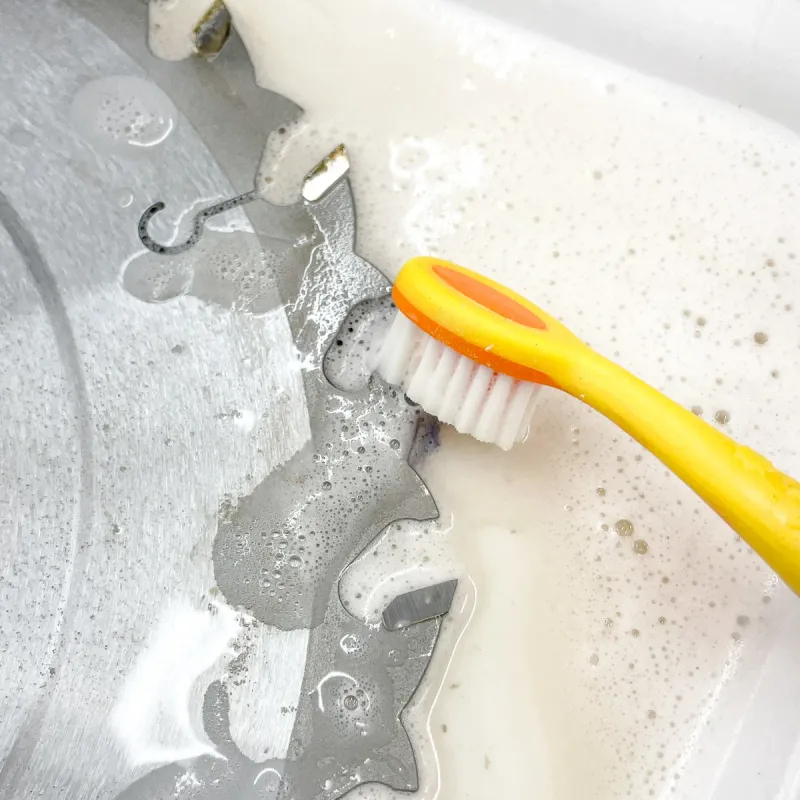 Toothbrush cleaning residue from a circular saw blade