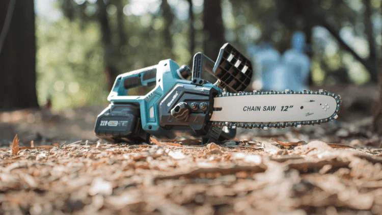 Cordless chainsaw resting on cut wood outdoors