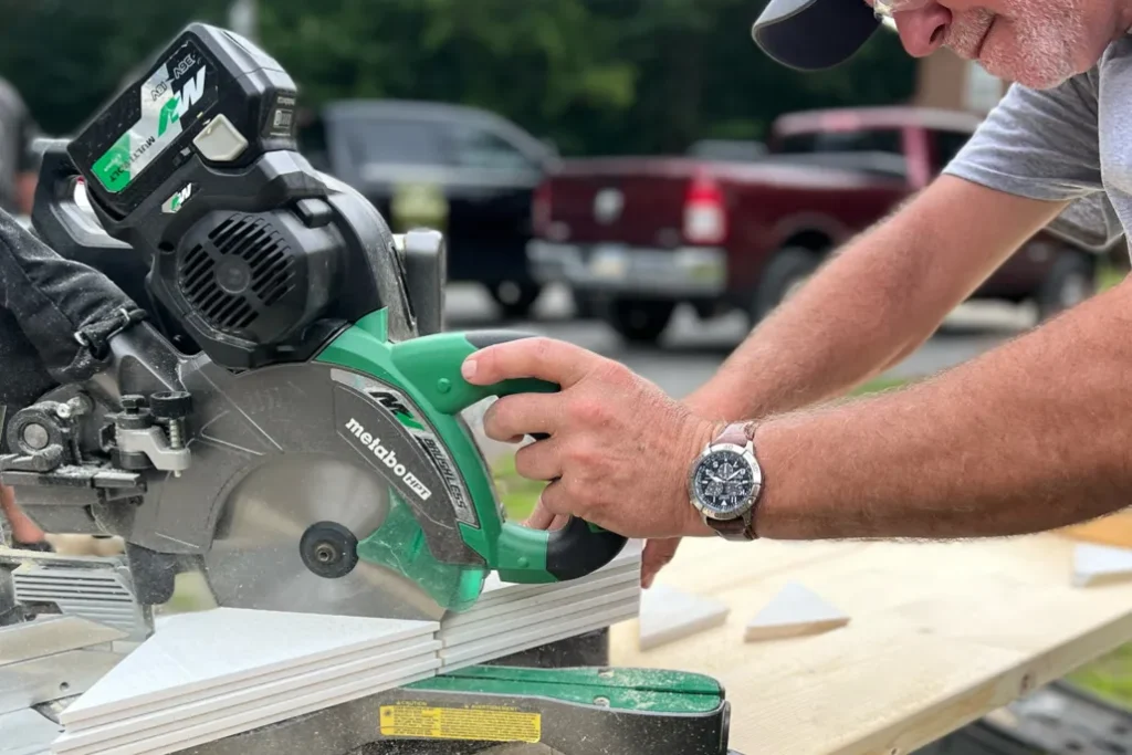 Cordless miter saw cutting trim on a workbench
