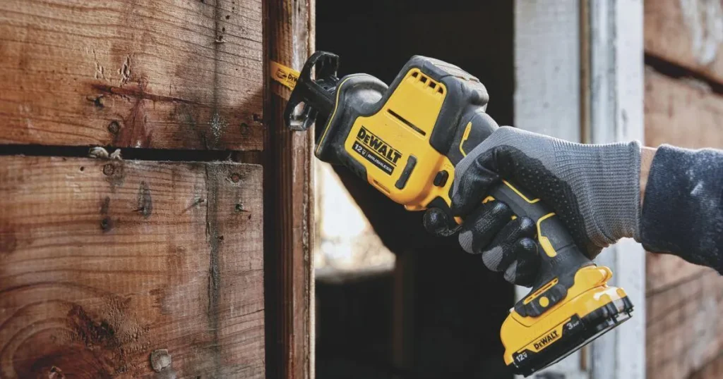 Cordless reciprocating saw cutting through wood