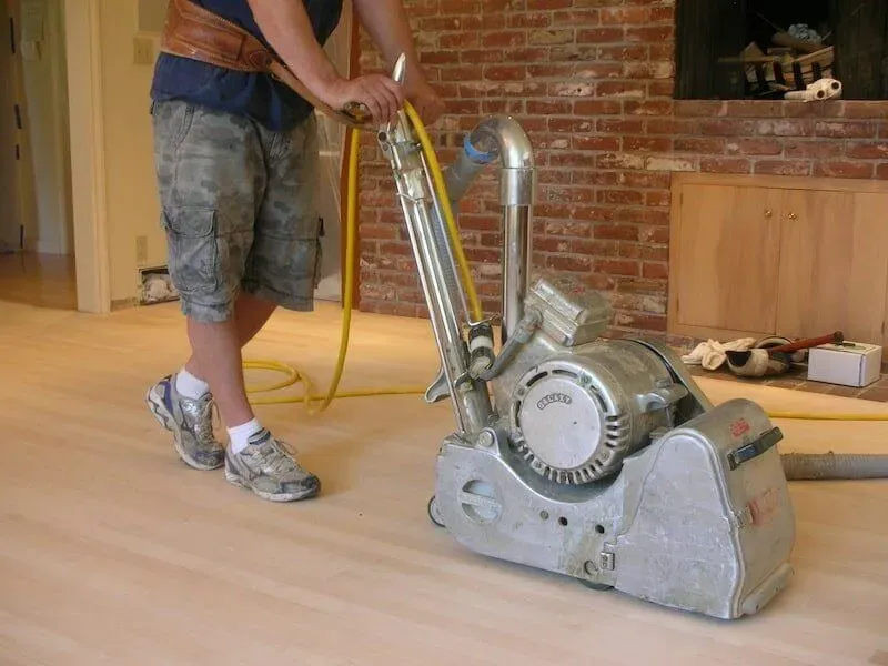 Operator handling a floor drum sander