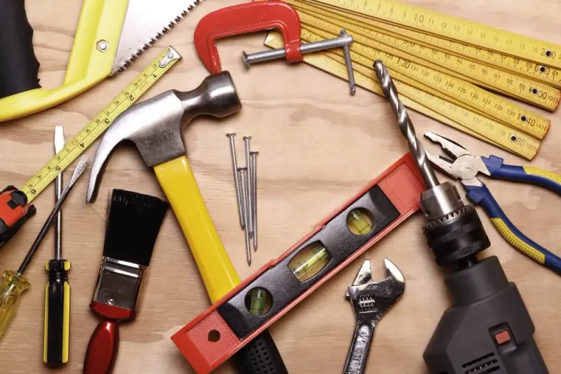Manual and power tools arranged on a workshop table