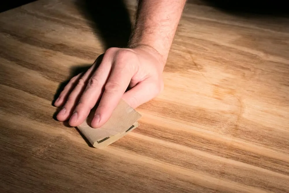 Hand sanding a wood surface