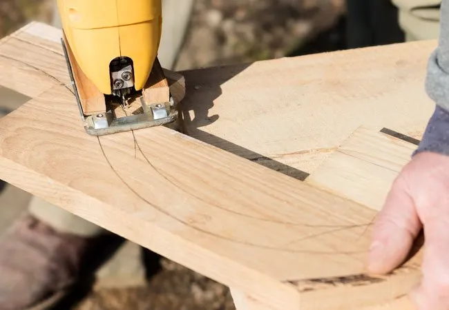 Jigsaw cutting a curved line in a wooden board
