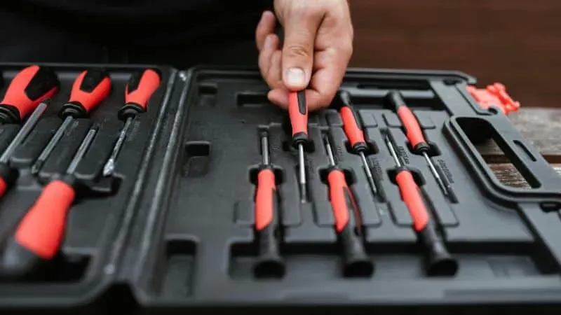 Person selecting a screwdriver bit from a tool case