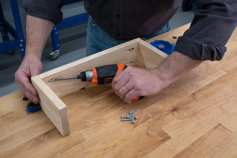 Manual screwdriver fastening a small wooden frame