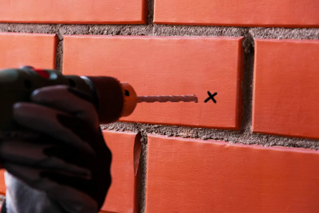 Marking a proposed drilling position on brick