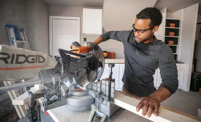 Woodworker operating a miter saw
