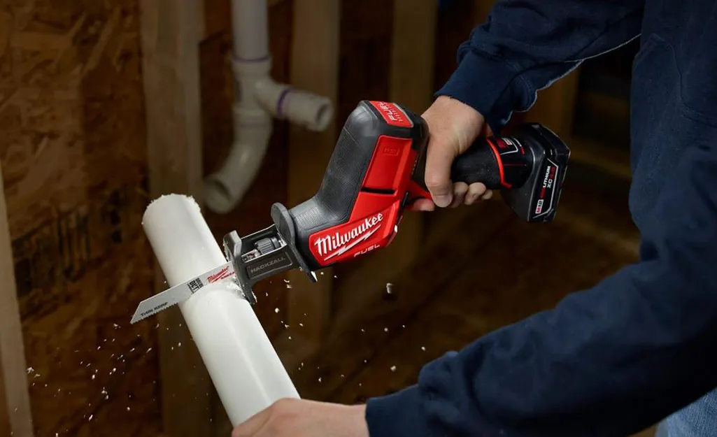Compact reciprocating saw cutting plastic pipe
