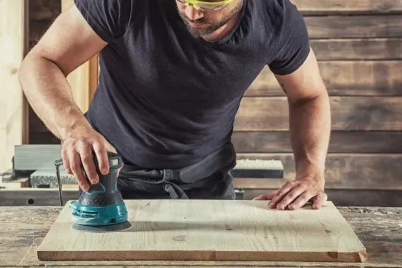 Orbital sander working across a supported board