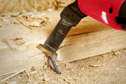 Oscillating multi-tool blade making a plunge cut in wood