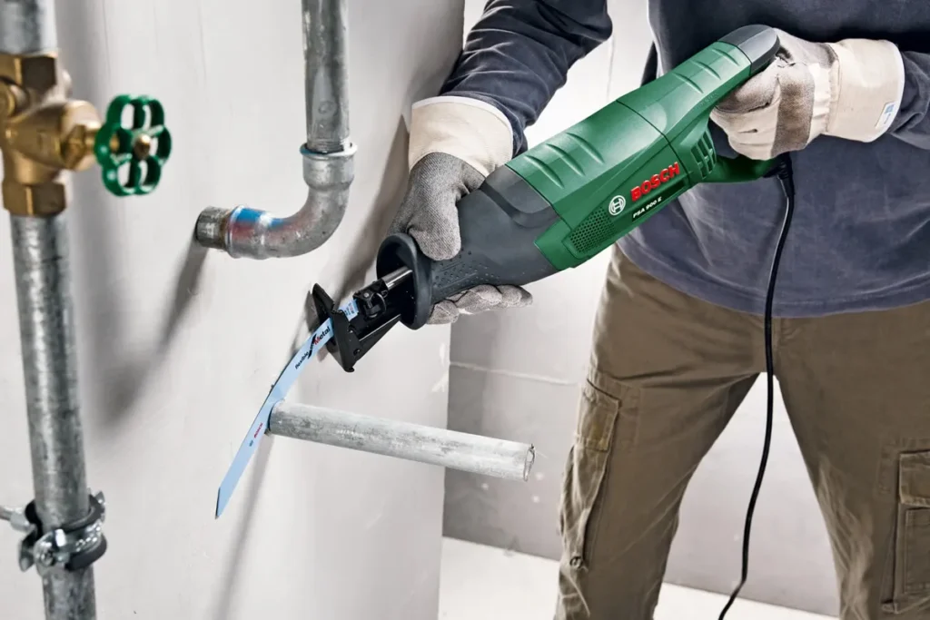 Reciprocating saw cutting a supported metal pipe
