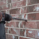 Rotary hammer drilling into a brick wall