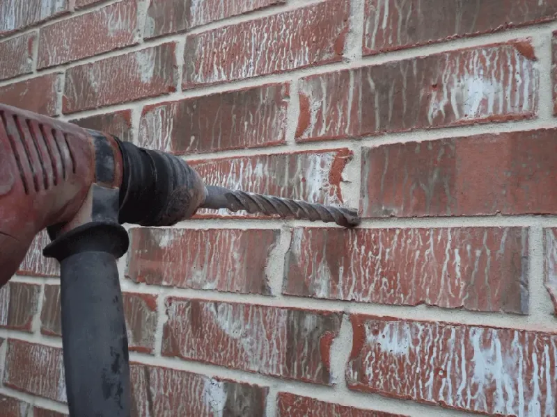 Rotary hammer drilling into a brick wall
